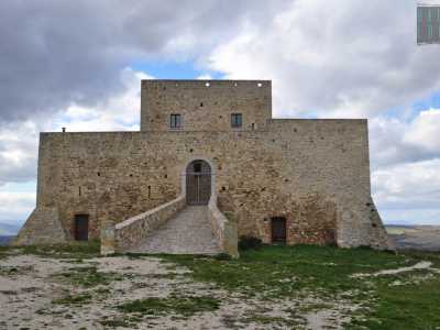 ...preceduta da ingresso in salita che porta davanti un arco protetto da un cancello in ferro